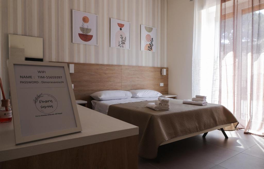 a hotel room with a bed and a sign in it at Dimora Savoia in Naples