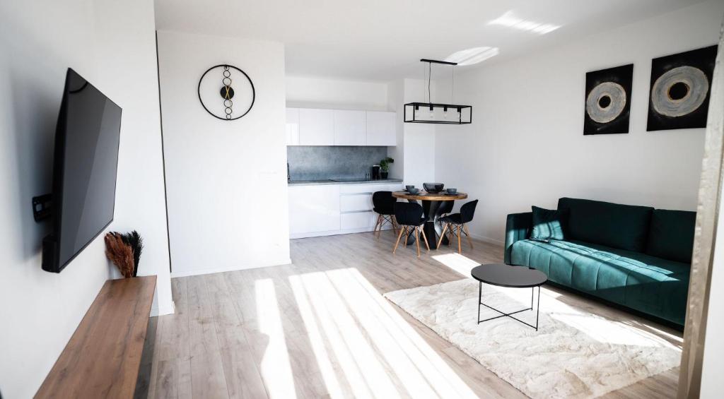 Una sala de estar con un sofá verde y una mesa. en Downtown28 apartment, en Poprad