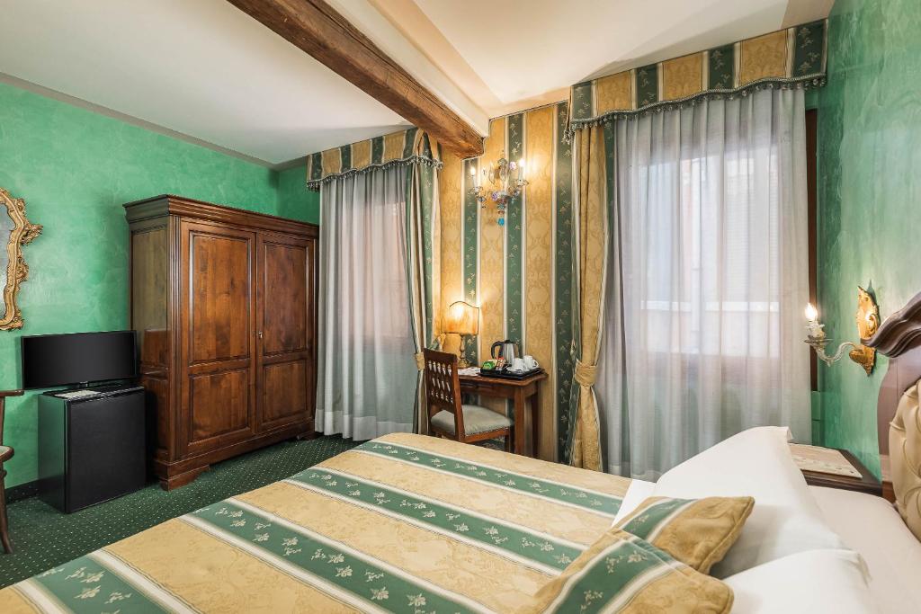 a bedroom with green walls and a bed and a desk at Hotel Marconi in Venice