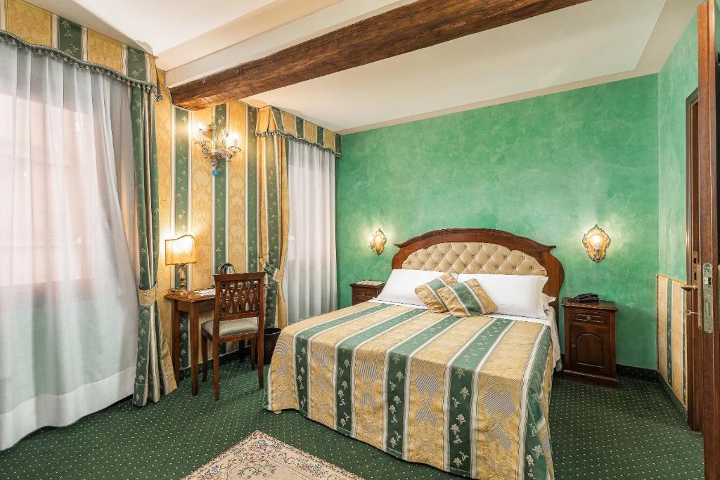 a bedroom with a bed with a green wall at Hotel Marconi in Venice