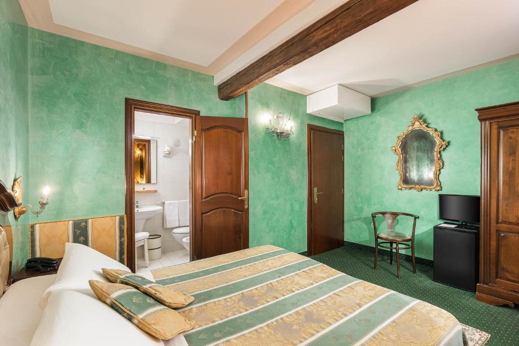 a bedroom with green walls and a bed and a bathroom at Hotel Marconi in Venice