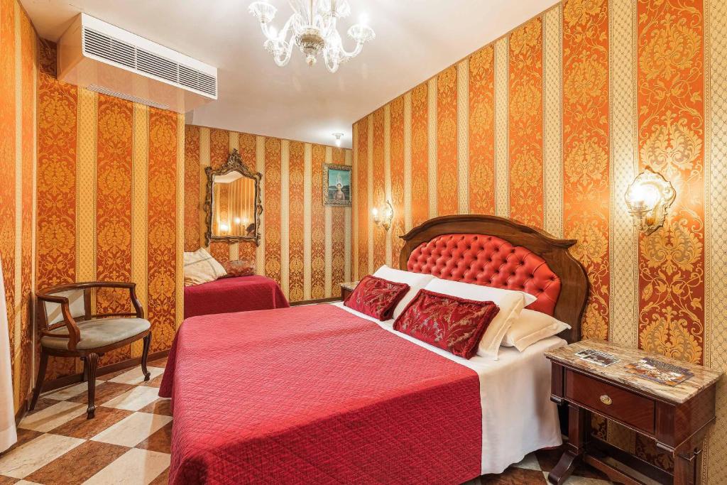 a bedroom with a red bed and a chair at Hotel Marconi in Venice