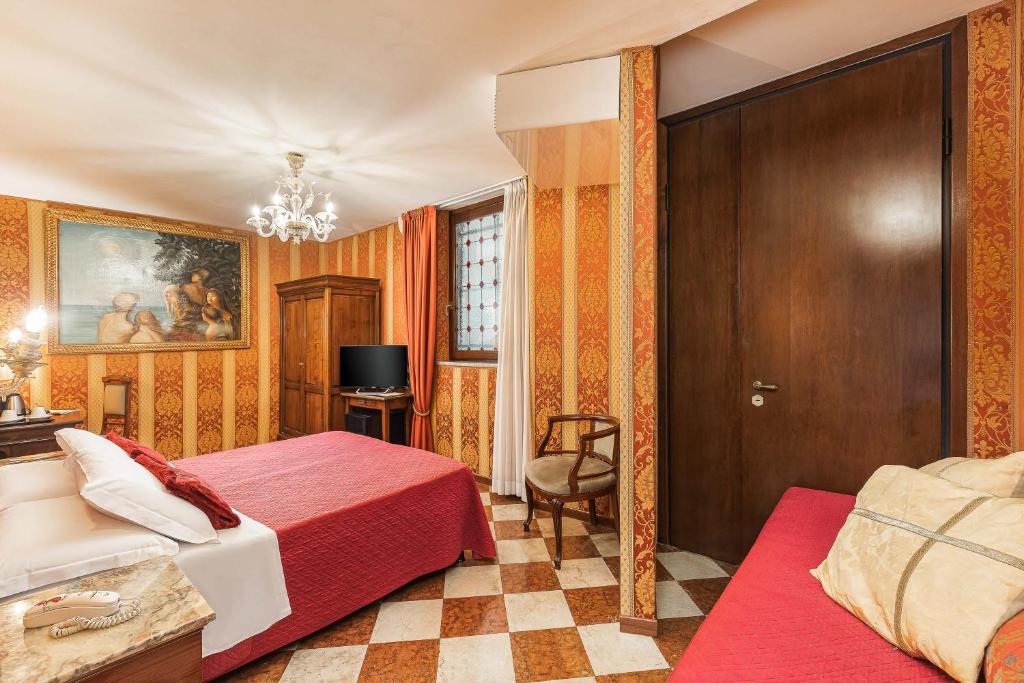 a bedroom with a bed and a chair and a door at Hotel Marconi in Venice