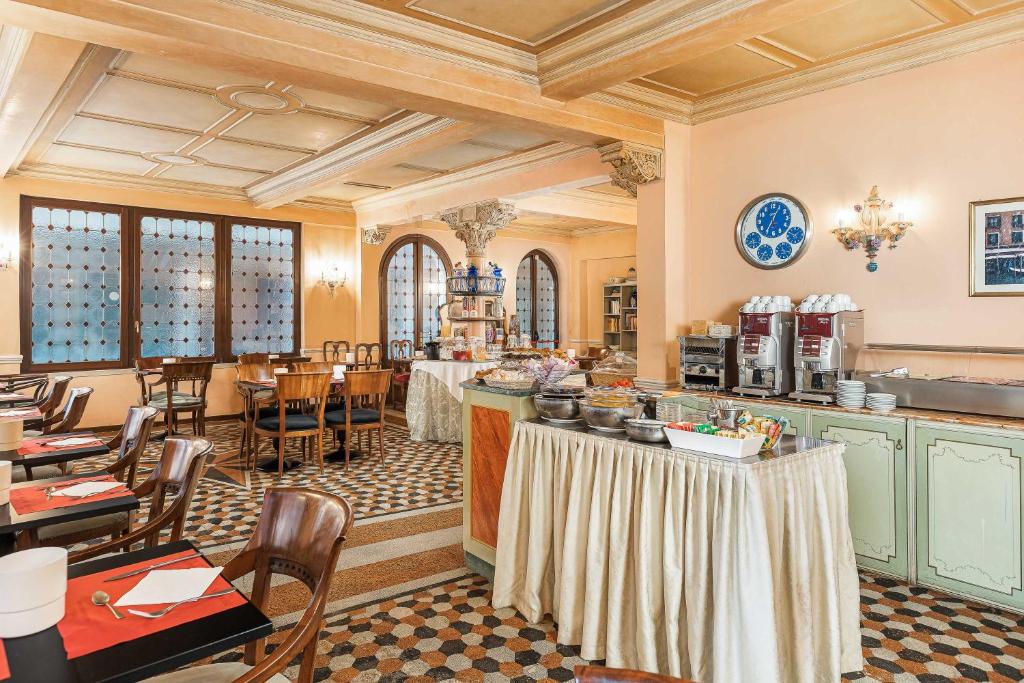 a restaurant with tables and chairs in a room at Hotel Marconi in Venice