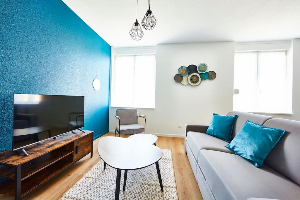 un salon avec un canapé et une télévision à écran plat dans l'établissement BM-1 Appartement au 1er étage - F2 - 1 à 4 pers, à Mulhouse