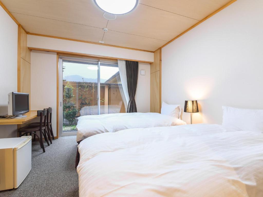Postel nebo postele na pokoji v ubytování はなぞの温泉 花圃の里