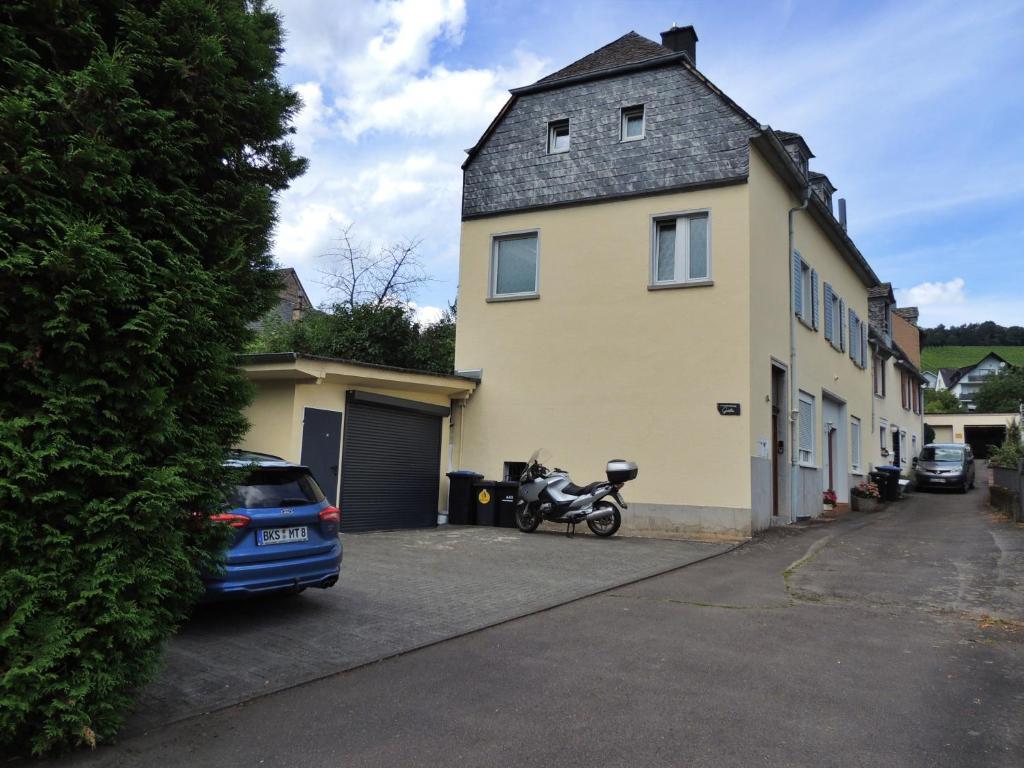 una moto parcheggiata di fronte a una casa gialla di Ferienwohnung Goethe a Bernkastel-Kues