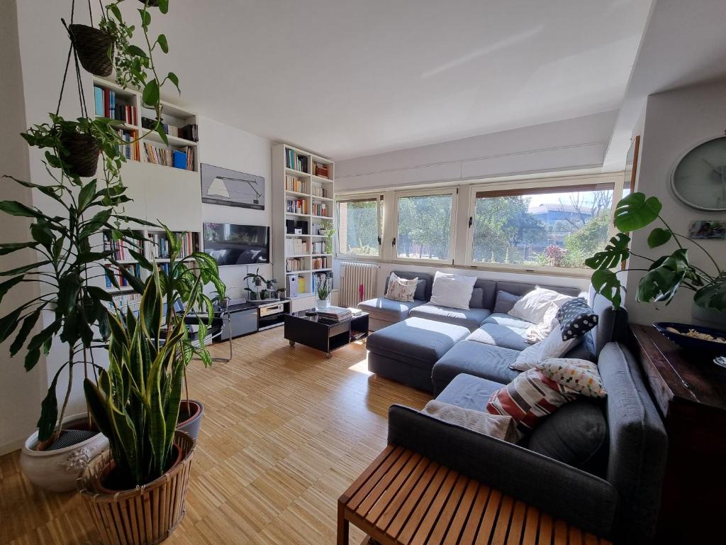 Hotel Parco della Musica House, a living room with a blue couch and a large window at Parco della Musica House in Rome