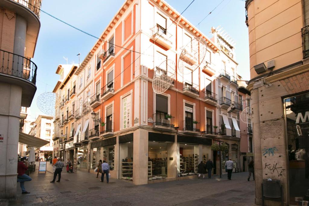 a building in a street with people walking around at Pension Mesones in Granada