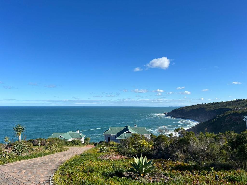 a dirt road leading down to a beach with houses at Blue Whale Resort in George