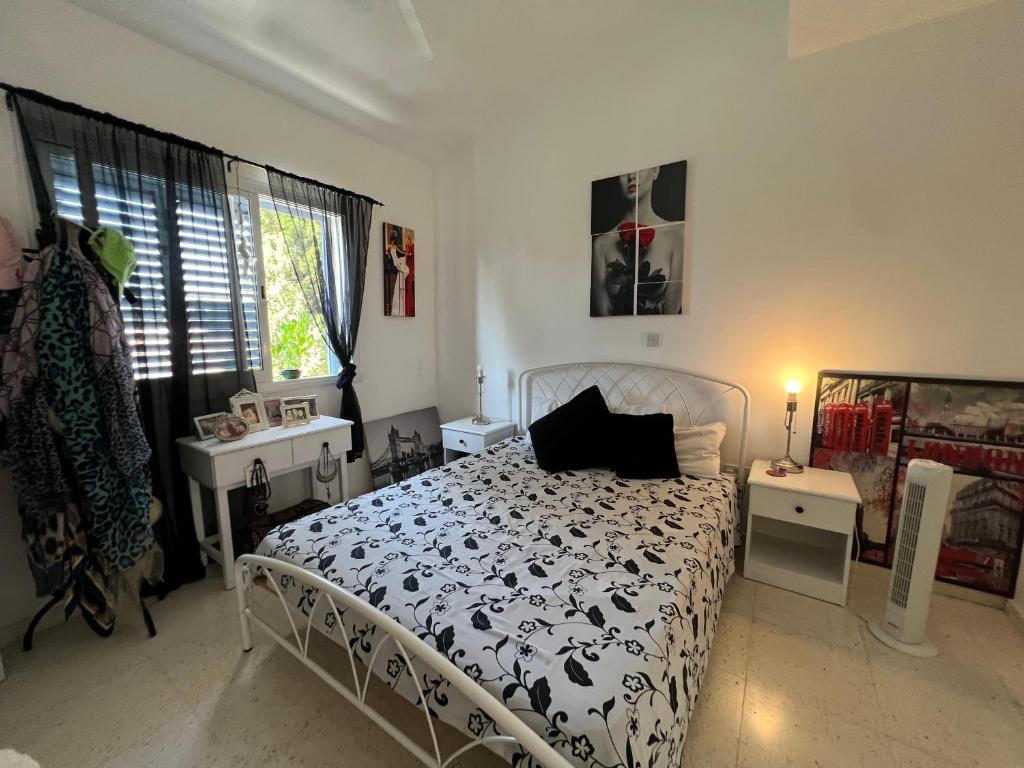 a bedroom with a black and white bed and a window at Natalia's 1 Bedroom Apartemnt in Paphos