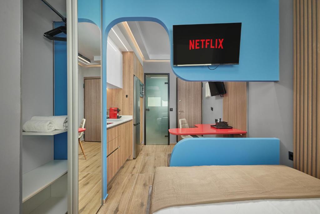 a room with a bed and a tv on the wall at ARETOUSA old town SUITE in Heraklio Town