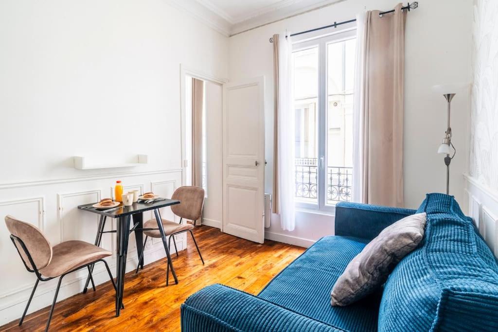 un salon avec un canapé bleu et une table dans l'établissement Blue 1 Bedroom #Montparnasse #Alésia, à Paris