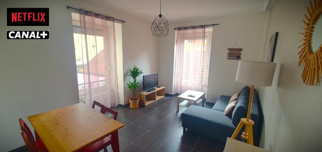 un salon avec un canapé bleu et une table dans l'établissement Le Central - wifi Netflix - Coeur de ville, à Belfort