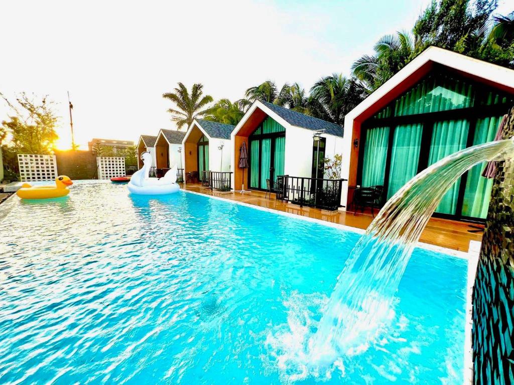 a pool at a resort with a water fountain at Plern-ura poolvilla cafe เพลินอุรา พูลวิลล่า คาเฟ่ in Ban Don Kha