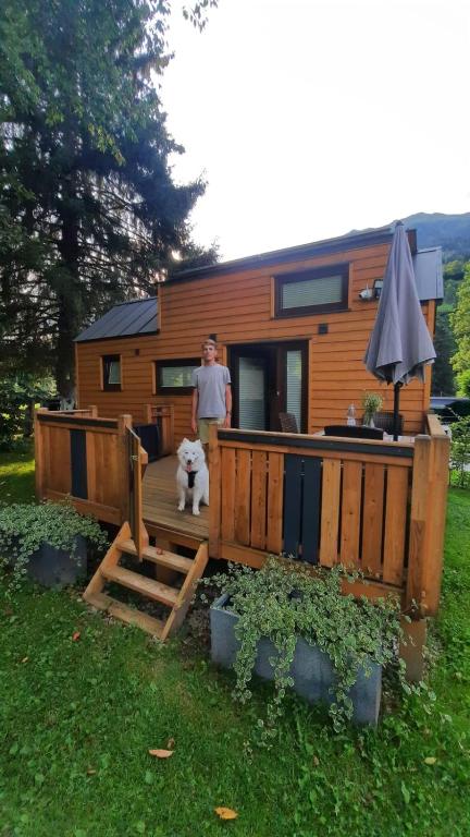 a man and a dog standing in front of a tiny house at Tiny House Waldschmied 1 in Latzendorf