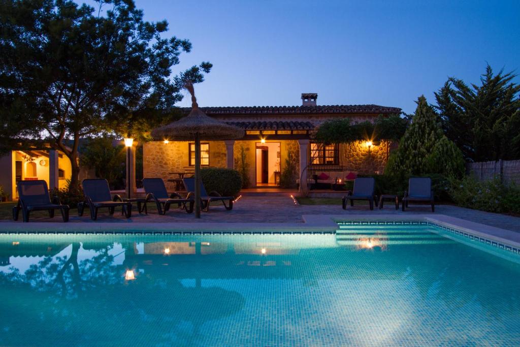 a swimming pool in front of a house at night at Can Daniel in Pollença