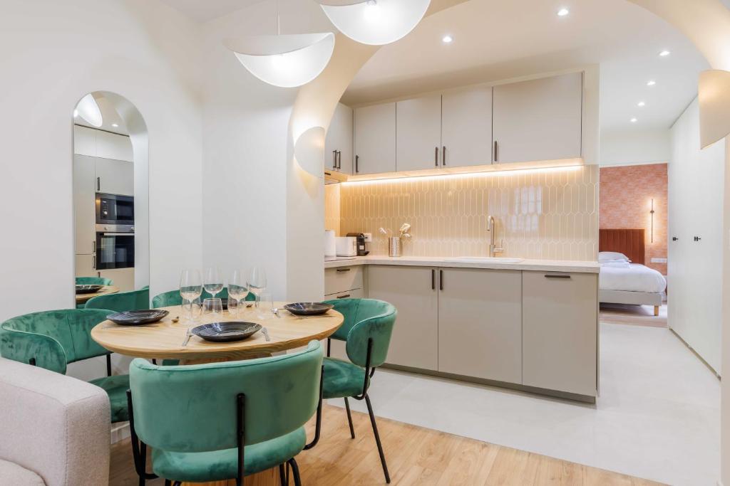 une cuisine et une salle à manger avec une table et des chaises vertes dans l'établissement Cozy Apartment 2BR-6P - Sacré-Coeur - Montmartre, à Paris