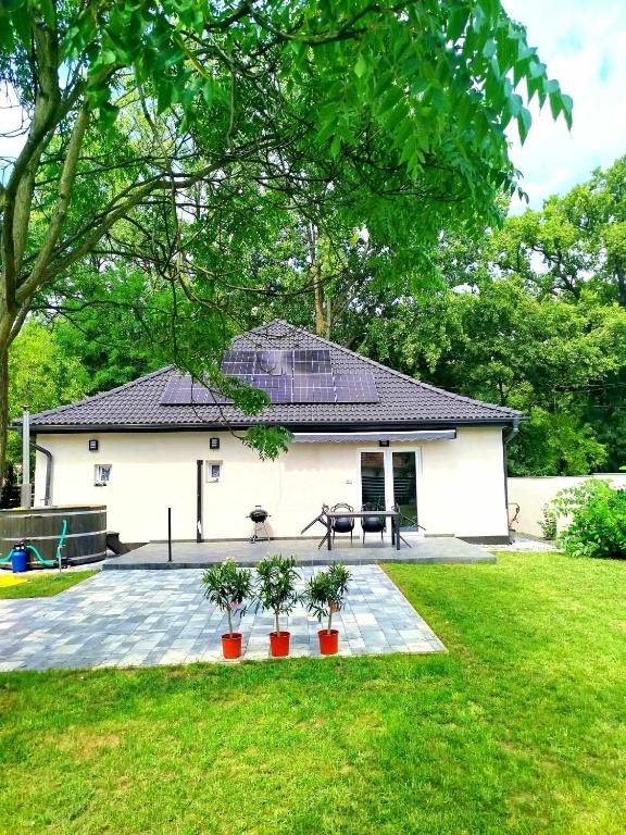 a white house with a patio and a table at Karát Apartmanok in Gyula