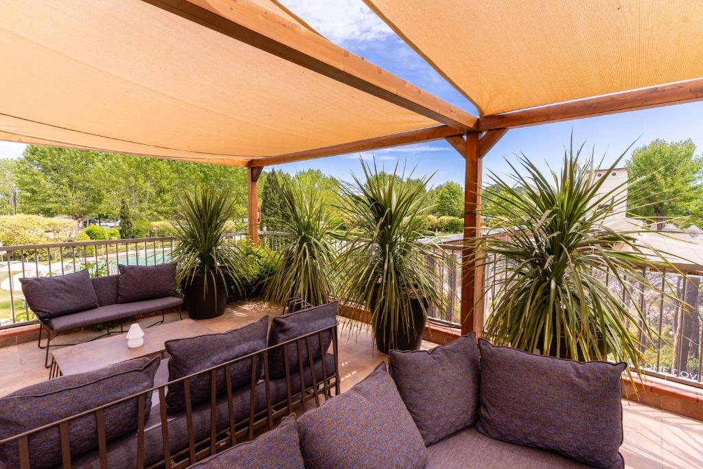 a patio with couches and palm trees at Club del Sole Viareggio Family Collection in Torre del Lago Puccini