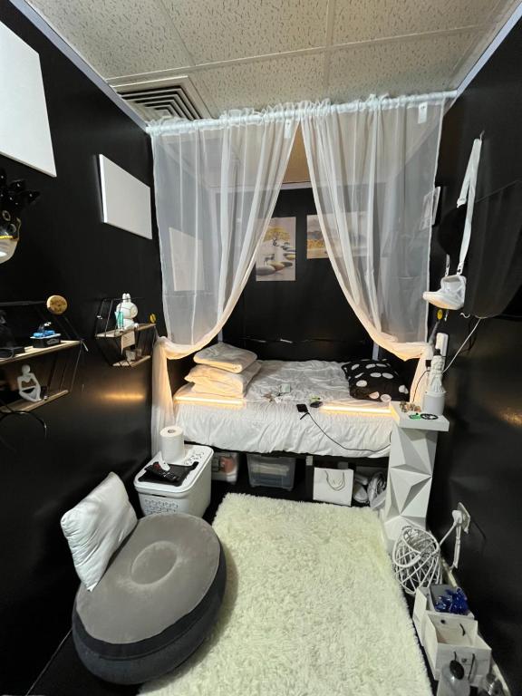 a small room with a bed with a curtain at Managa-naga Room1204 near abu dhabi mall in Abu Dhabi