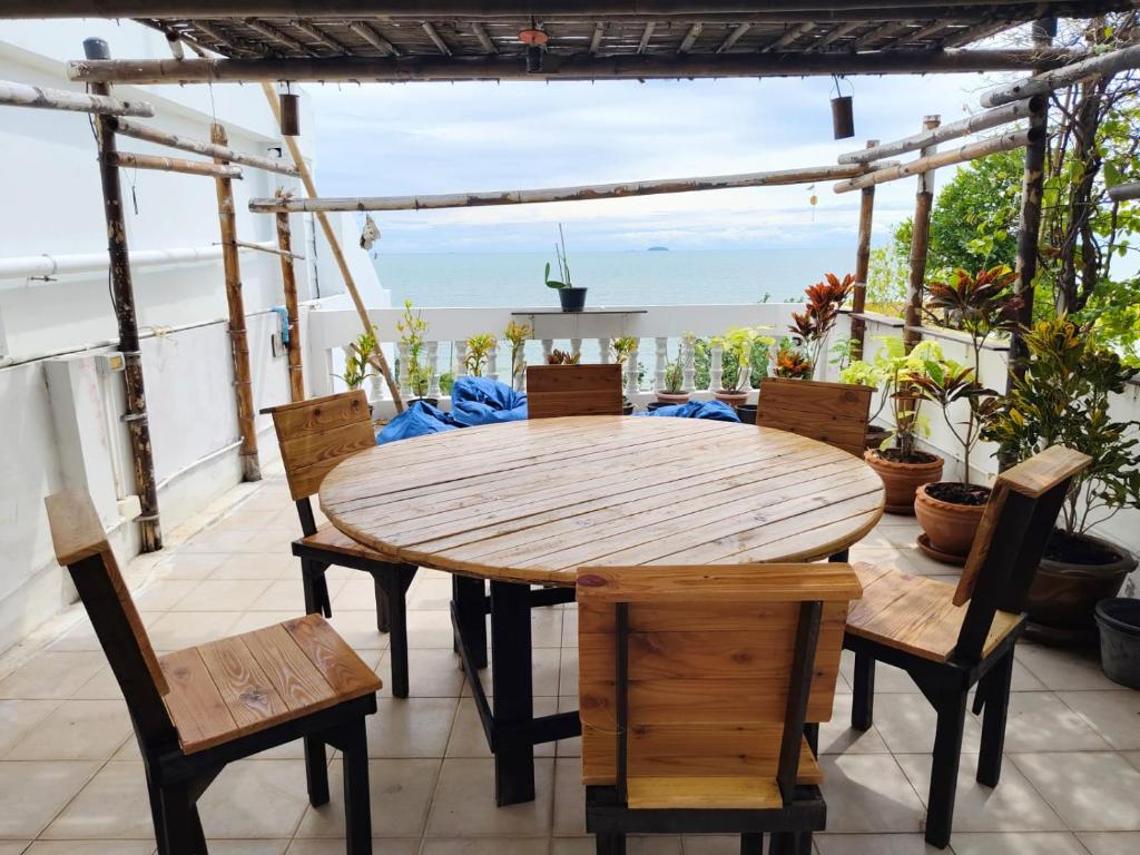 a wooden table and chairs on a patio at Beach Villa NA JOMBTIEN ROOF TOP in Na Jomtien