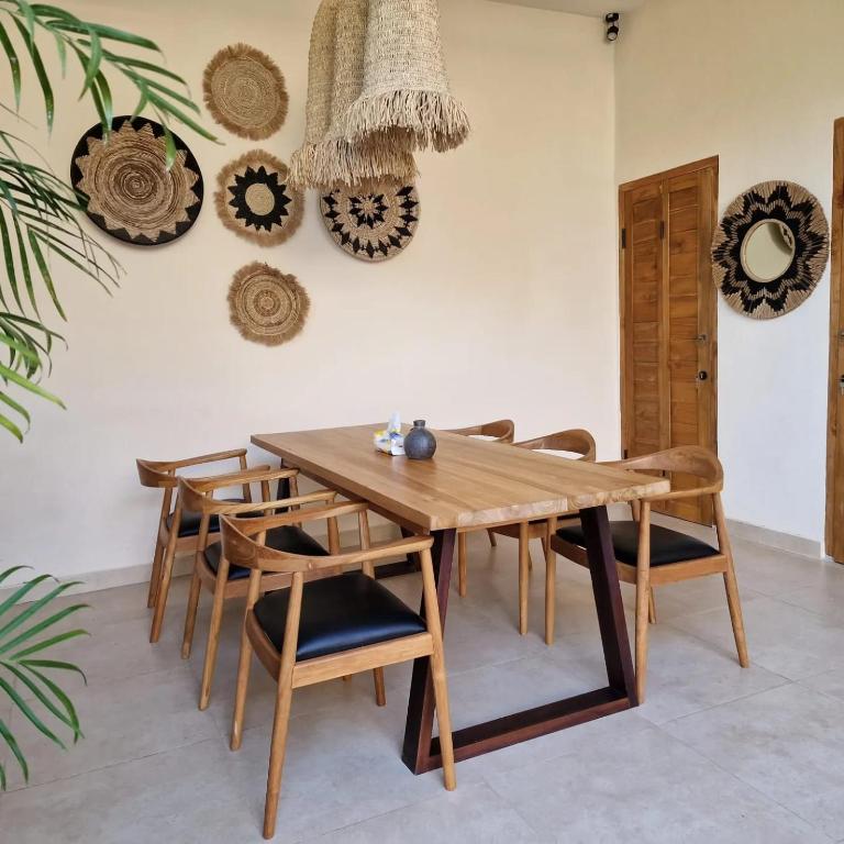 a dining room with a wooden table and chairs at LM Home Mendira in Candidasa