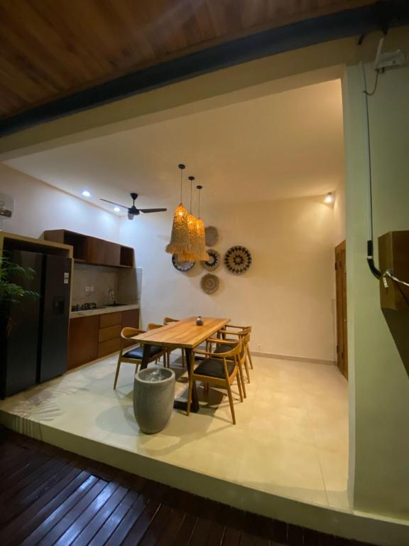 a kitchen and dining room with a wooden table and chairs at LM Home Mendira in Candidasa