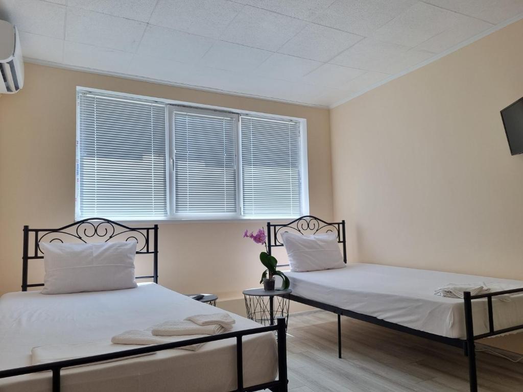 Dos camas en una habitación con ventana. en House Vesela, en Balchik