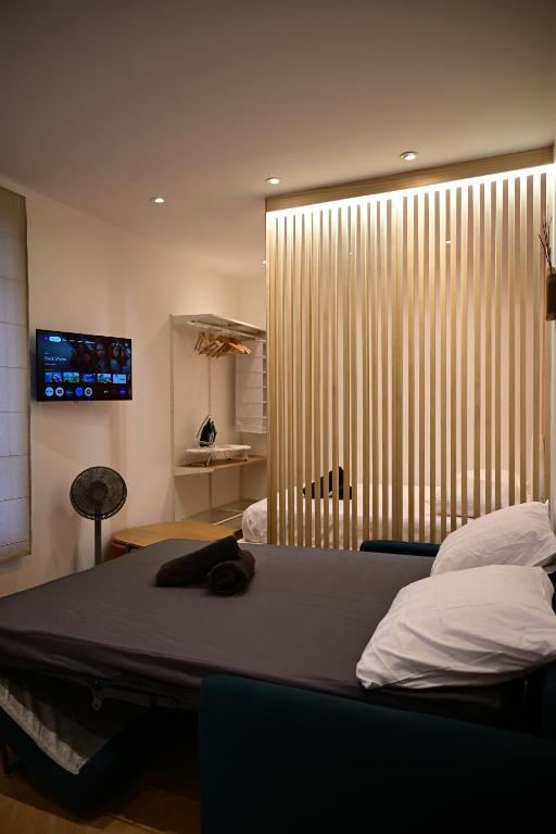 une chambre avec un lit et une grande fenêtre dans l'établissement Studio paris Rolland garros parc des princes TM, à Boulogne-Billancourt