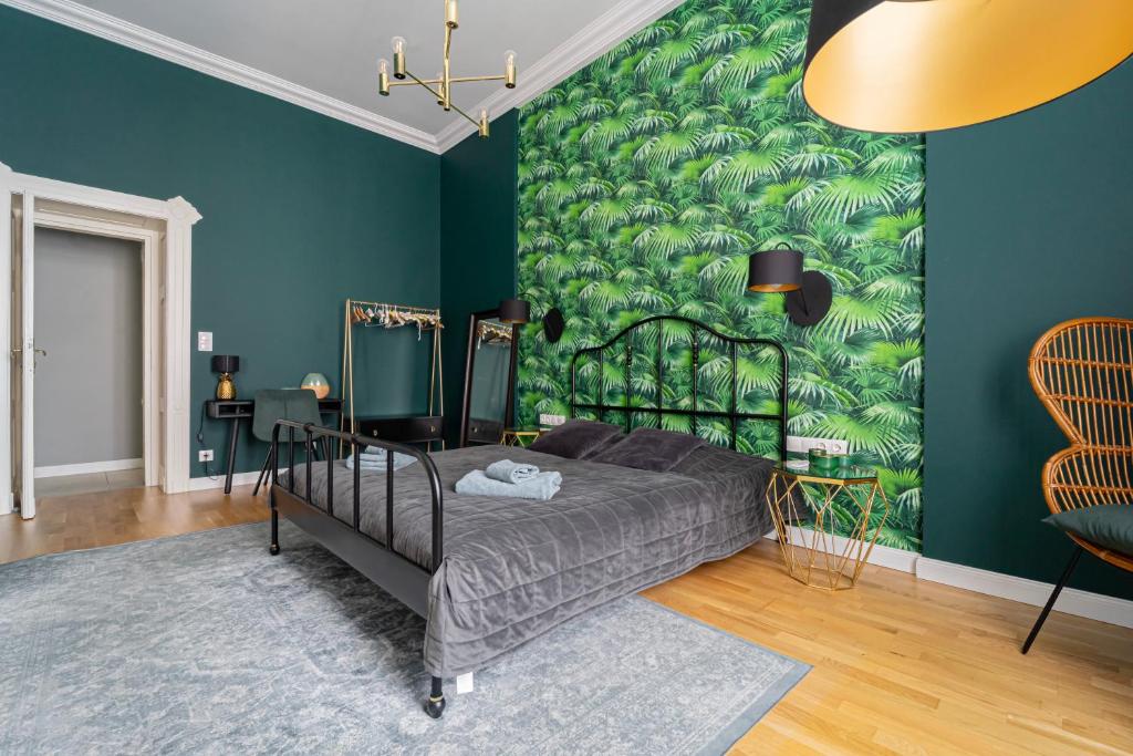 a bedroom with a bed with a green wall at Heart of City in Budapest