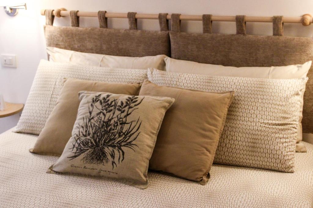 a bunch of pillows sitting on a bed at Relais Casa Moresca in Terracina