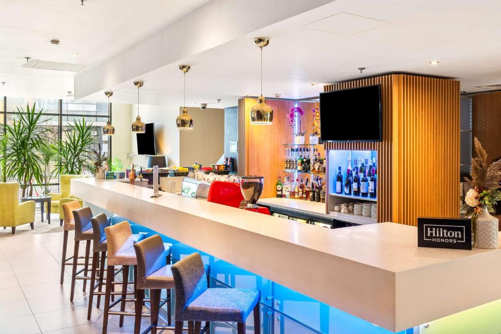 a bar in a restaurant with stools at Hampton by Hilton Cluj-Napoca in Cluj-Napoca