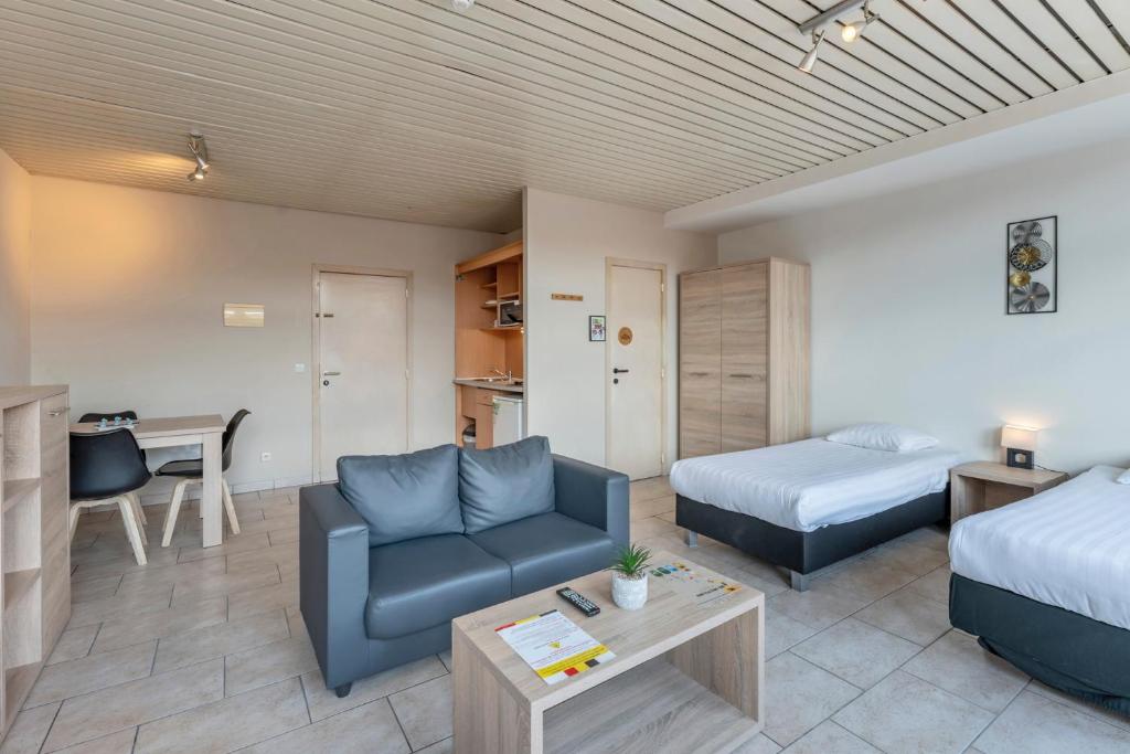 a room with a couch and a bed and a desk at Condo Gardens Brussels in Brussels
