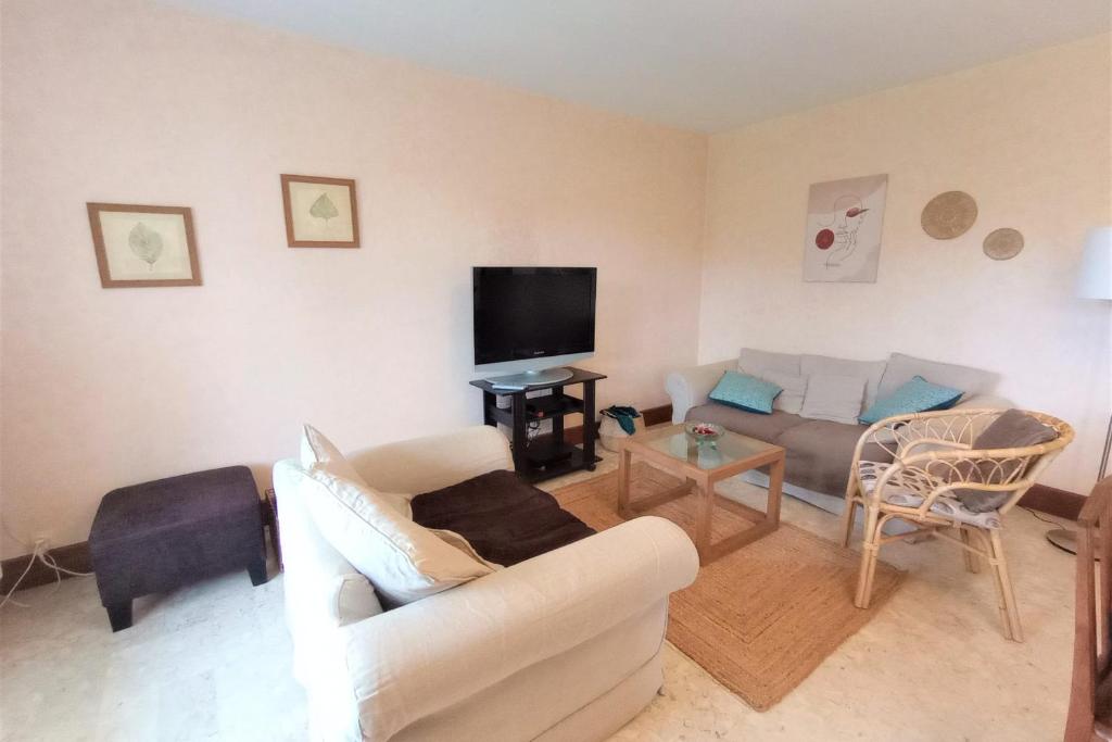 a living room with a couch and a tv at Le Florin d'Or - Bords de Creuse in Saint-Gaultier