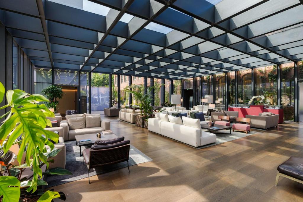 a lobby with a lot of furniture and windows at Hilton Lake Como in Como
