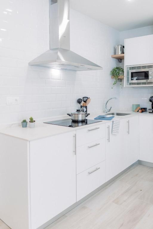 Apartamento El EnTorno في Valle de Abdalagís: مطبخ أبيض مع دواليب بيضاء ومغسلة