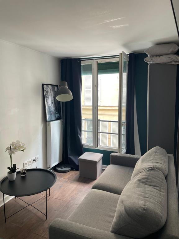 un salon avec un canapé et une table dans l'établissement Studio lumineux Batignolles, à Paris