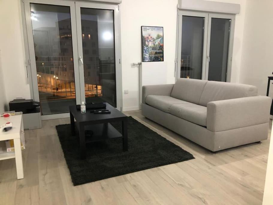 a living room with a couch and a coffee table at Les jardins d'abraxas in Noisy-le-Grand