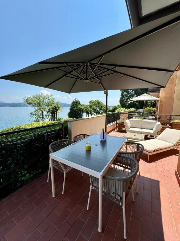 a table and chairs with an umbrella on a patio at Lago Bello in Stresa