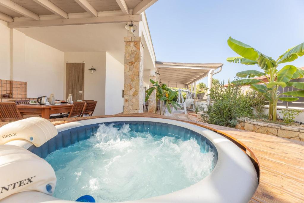a hot tub on the deck of a house at Villetta Camelia in Marina di Mancaversa
