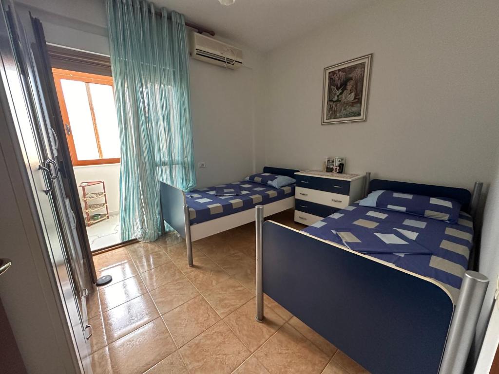a bedroom with two beds and a window at Cozy Room For Rent Near Beach in Vlorë