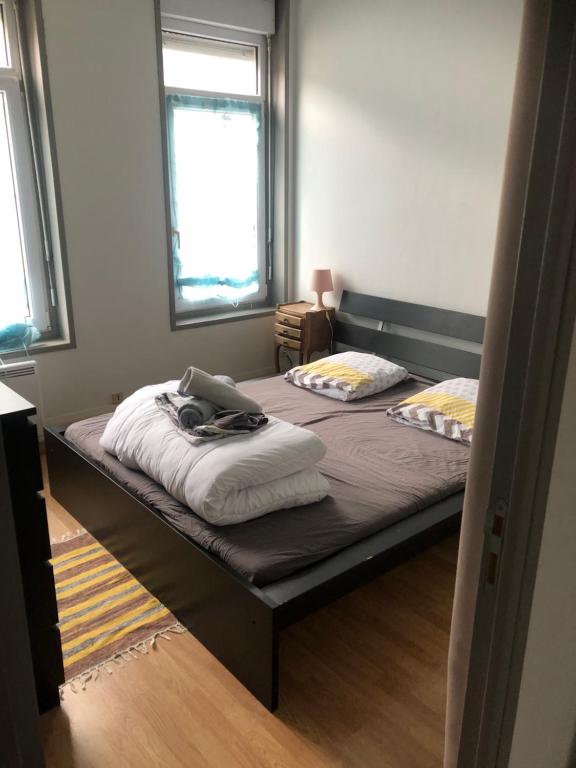 une chambre avec deux lits avec des serviettes dessus dans l'établissement Appartement proche de la mer, à Dunkerque