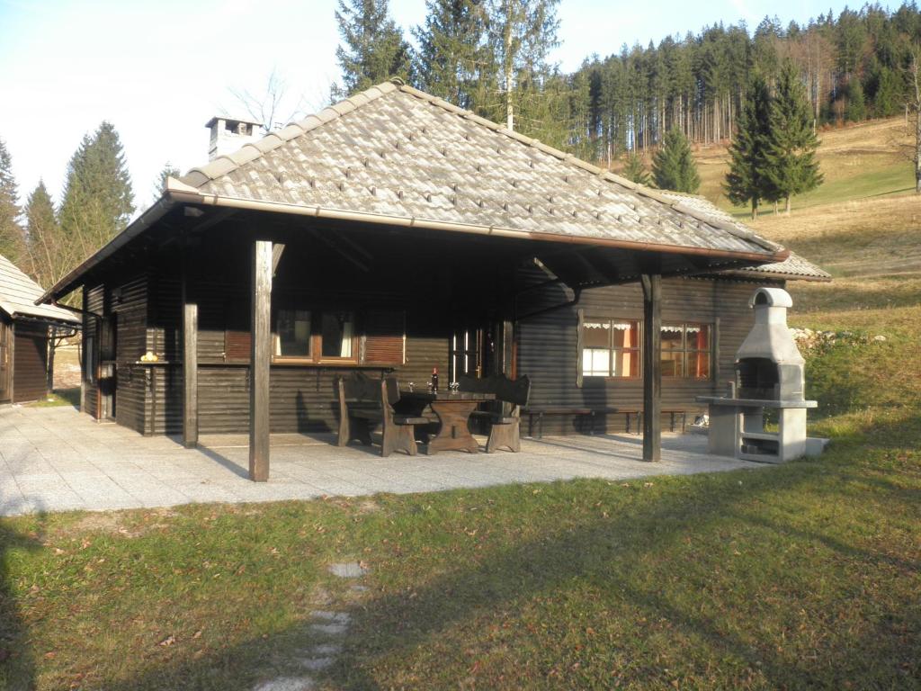 Cabaña de madera con mesa y sillas en Holiday Home Čumar, en Cerkno