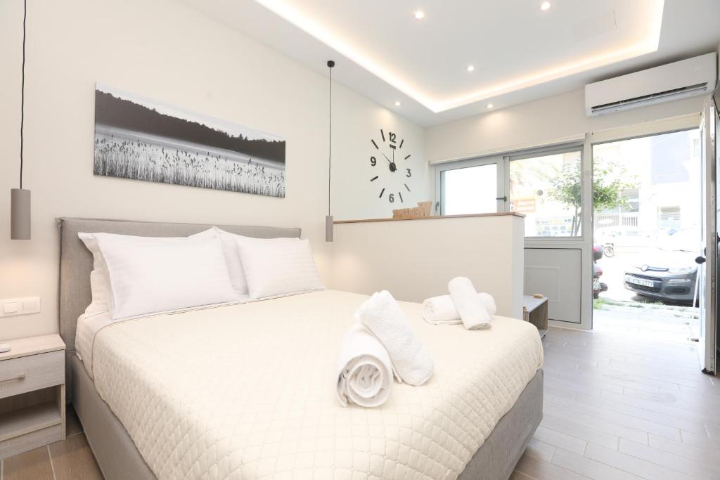una camera da letto con un letto bianco con cuscini bianchi di Borgo Eleganza Suite, Corfu Town a Città di Corfù