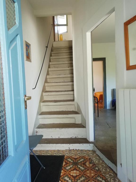 un escalier dans une maison avec une porte bleue dans l'établissement Chez Pauline, à Murviel-lès-Montpellier