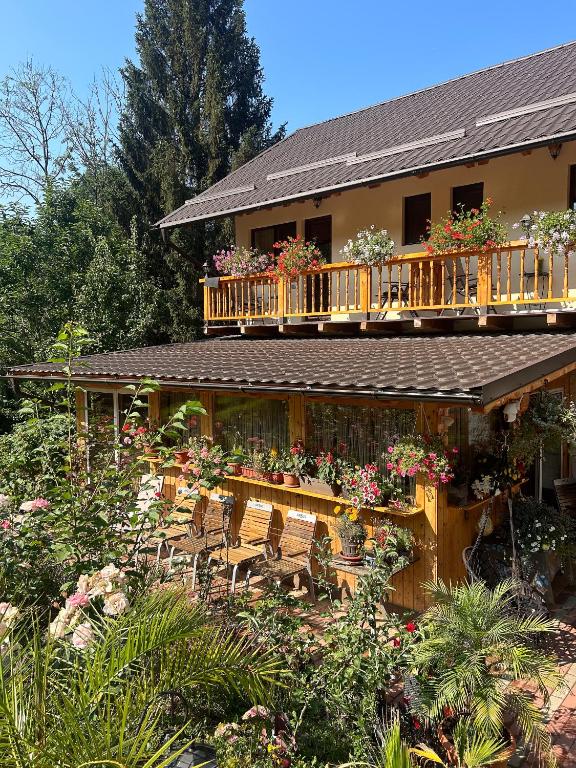 Una casa con una terraza con flores. en Casa Armonia, en Bran