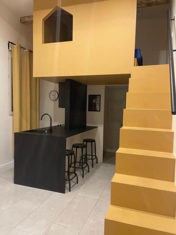 une cuisine avec un escalier menant à une cuisine avec un comptoir dans l'établissement Joli studio, à Marseille