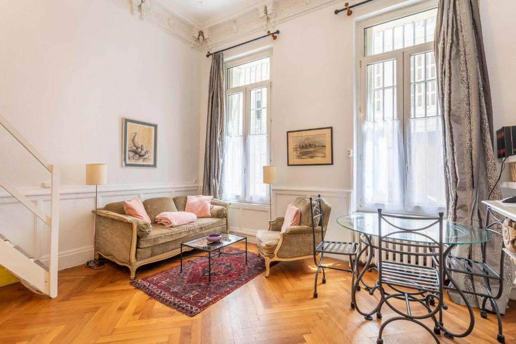 un salon avec un canapé et une table en verre dans l'établissement 1 bedroom duplex with AC near the Old Port, à Marseille