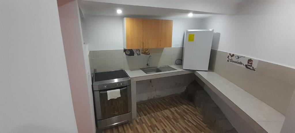 a small kitchen with a sink and a refrigerator at Casa Apartamento en un lugar encantador de la Naturaleza in Hacienda Chichavo
